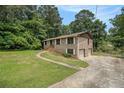 Brick home with an attached garage, and a walkway leading to the front door at 530 Village Green Sw Ct, Lilburn, GA 30047