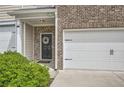 Close-up of the townhome's front door and two-car garage, with a wreath on the door at 3070 Fareed St, Douglasville, GA 30135