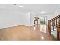 Bright, open-concept living area with hardwood flooring and a seamless transition to a modern kitchen with wood cabinetry at 3227 Fescue Cir, Lawrenceville, GA 30044