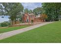 A view of the property showing a well maintained lawn and long driveway at 1952 Skidmore Cir, Lawrenceville, GA 30044