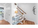 Bright entryway featuring hardwood floors, a staircase with wooden railings, and decorative wall hooks at 2093 Kolb Ridge Sw Ct, Marietta, GA 30008