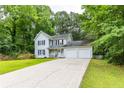 Charming two-story home with white siding, black shutters, a cozy front porch, and an attached two-car garage at 2093 Kolb Ridge Sw Ct, Marietta, GA 30008