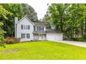 Charming two-story home with white siding, black shutters, a cozy front porch, and an attached two-car garage at 2093 Kolb Ridge Sw Ct, Marietta, GA 30008