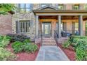Charming front porch with brick columns, elegant door, and a cozy seating area at 2996 Walkin Horse Trl, Buford, GA 30519