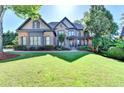 Lovely two-story home featuring a well-maintained lawn, stone accents, and lush landscaping at 2996 Walkin Horse Trl, Buford, GA 30519