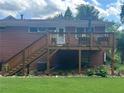 A wooden back deck with stairs overlooks the lush green lawn and garden, creating an inviting outdoor space at 388 Talcott Nw Cir, Marietta, GA 30064