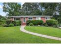 Charming brick home with a lush green lawn and tidy shrubbery at 388 Talcott Nw Cir, Marietta, GA 30064