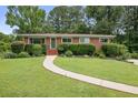 Lovely single-story brick home with a lush green lawn and manicured shrubbery at 388 Talcott Nw Cir, Marietta, GA 30064