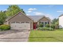 Welcoming single-story house featuring a red front door and attached two-car garage at 1615 Nw Vinebrook Nw Ter, Kennesaw, GA 30144