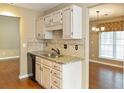 Compact kitchen featuring granite countertops, tiled backsplash, and wooden floors at 1615 Nw Vinebrook Nw Ter, Kennesaw, GA 30144