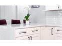 Bright kitchen featuring white cabinets, quartz countertops, sleek black hardware, and decorative floral arrangement at 4541 Meadow Club Dr, Suwanee, GA 30024