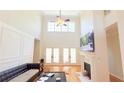 Bright living room with a black sofa, high ceilings, fireplace and hardwood floors at 4541 Meadow Club Dr, Suwanee, GA 30024