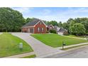 A lovely brick home sits on a large lot with a sprawling driveway and mature trees at 9507 Greens Mill Ct, Loganville, GA 30052