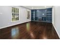 Bright living room featuring hardwood floors and custom built-in shelving at 1663 Pounds Sw Rd, Stone Mountain, GA 30087