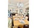 Elegant dining room with a chandelier, tray ceiling, and a table set for a formal meal at 5430 Lemoyne Sw Dr, Atlanta, GA 30331