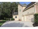 Exterior view of a two-car garage with a concrete driveway and well-maintained landscaping at 6570 Canyon Cv, Cumming, GA 30028