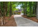 Long driveway leading to a two-story brick home with a spacious garage, surrounded by trees at 1772 Benningfield Sw Dr, Marietta, GA 30064