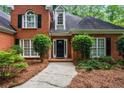 Inviting brick home featuring a front door flanked by lush landscaping and bright windows at 1772 Benningfield Sw Dr, Marietta, GA 30064