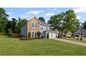 Beautifully landscaped home with lush green lawn, attached garage, and mature shade trees at 2261 Seatton Ct, Marietta, GA 30062