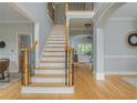 Bright and airy foyer with hardwood floors, staircase, and views into other rooms at 6610 Major Dr, Cumming, GA 30040
