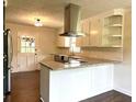 Open kitchen with an island, stainless steel hood, granite countertops, and hardwood floors at 942 Batesville Rd, Canton, GA 30115