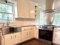 Bright kitchen with stainless steel appliances, granite counters, and a farmhouse sink at 942 Batesville Rd, Canton, GA 30115