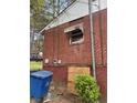 View of brick wall, window, trash receptacle and shrubbery outside this home at 2625 Baker Nw Rd, Atlanta, GA 30318
