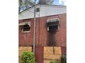 Exterior image showing brick siding, boarded window, and shrubbery at 2625 Baker Nw Rd, Atlanta, GA 30318