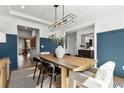 An additional view of this dining room boasts elegant decor, a modern chandelier, and natural light at 5350 Hyde Rd, Cumming, GA 30040