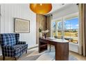 Well-lit office features stylish decor, a comfortable chair, a wooden desk, and a large window overlooking the yard at 5350 Hyde Rd, Cumming, GA 30040