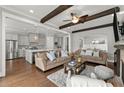 Open concept living room featuring hardwood floors, comfortable sofas, and wood beam ceiling accents at 1104 Victoria Ne St, Brookhaven, GA 30319