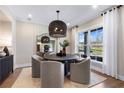 Cozy dining area with a round table, stylish chairs, a modern light fixture, and natural light at 5360 Hyde Rd, Cumming, GA 30040