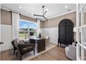 Well-lit home office with dark wood desk, stylish decor, and large windows offering natural light at 5360 Hyde Rd, Cumming, GA 30040