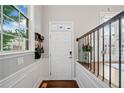 Bright foyer with hardwood floors, white wainscoting, and transom window above the front door at 6054 China Rose Ln, Duluth, GA 30097