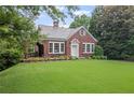 Charming brick home with a lush green lawn and beautiful landscaping at 655 E Pelham Ne Rd, Atlanta, GA 30324