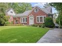 Brick home with manicured lawn, covered patio, and convenient driveway at 655 E Pelham Ne Rd, Atlanta, GA 30324