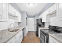 Updated kitchen featuring white cabinets, granite countertops, and stainless steel appliances at 122 Rue Fontaine, Lithonia, GA 30038