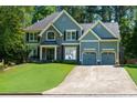 Attractive two-story home with a manicured lawn, stone accents and a spacious two-car garage at 2015 Towne Lake W Hls, Woodstock, GA 30189