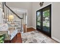 Inviting foyer with hardwood floors, black french doors, staircase, and bright, neutral decor at 2015 Towne Lake W Hls, Woodstock, GA 30189