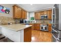 Well-equipped kitchen with stainless steel appliances, wood cabinets, and spacious countertops at 2015 Towne Lake W Hls, Woodstock, GA 30189