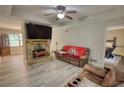 Inviting living room featuring a stone fireplace, modern ceiling fan, and wood-look flooring at 1638 River Trce, Auburn, GA 30011
