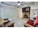 Cozy living room with stone fireplace, ceiling fan, and durable light-colored flooring at 1638 River Trce, Auburn, GA 30011