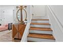 Bright foyer with wooden floors on stairs complemented by a decorative mirror and cabinet at 3147 Buford Ne Hwy # 8, Brookhaven, GA 30329