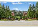 Exterior of gated community entrance with brick townhomes and beautiful landscaping at 4298 Kingston Gate Cv, Chamblee, GA 30341