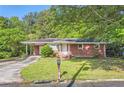 Inviting single-story brick home with a covered carport, lush greenery, and a classic mailbox at 7577 Haley Dr, Jonesboro, GA 30236