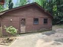 Exterior view of a rustic cabin home featuring natural wood siding at 418 Honey Suckle Ln, Stockbridge, GA 30281