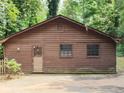 Charming exterior view showcasing natural wood siding with lush landscaping at 418 Honey Suckle Ln, Stockbridge, GA 30281