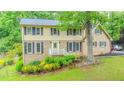 Charming two-story home featuring brick and vinyl siding, well-kept lawn, and mature trees at 5293 Sandy Shoals Ln, Stone Mountain, GA 30087