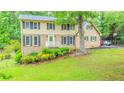 Charming two-story home featuring brick and vinyl siding, well-kept lawn, and mature trees at 5293 Sandy Shoals Ln, Stone Mountain, GA 30087