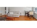 Open living area with hardwood floors, a comfortable sofa, and a dining area by the windows at 690 Piedmont Ne Ave # 17, Atlanta, GA 30308